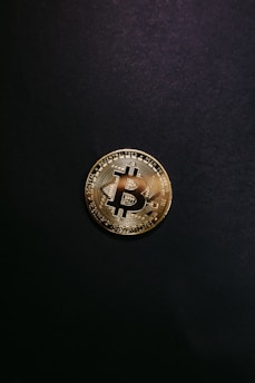 a bit coin sitting on top of a black surface
