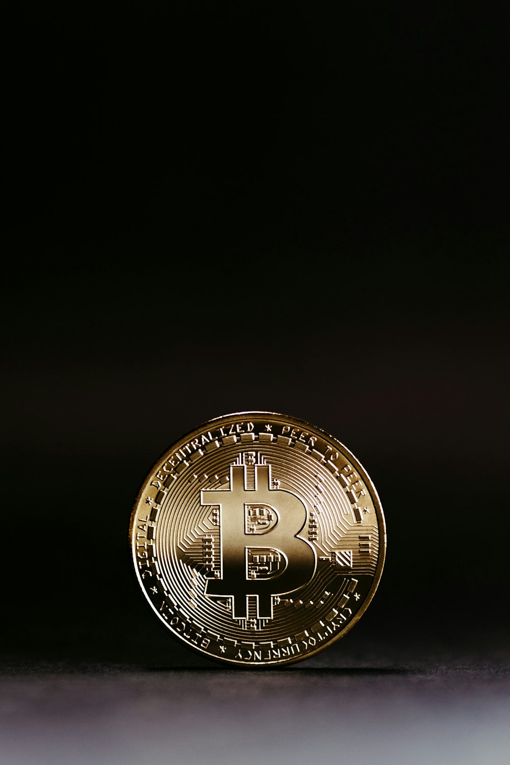 a gold bitcoin sitting on top of a table