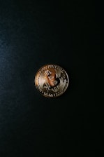 Close-up of a digital bitcoin coin glowing against a dark background.