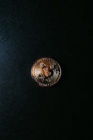 Close-up of a digital bitcoin coin glowing against a dark background.