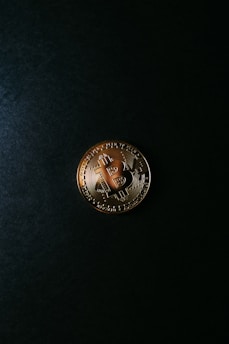 a bitcoin sitting on top of a black surface