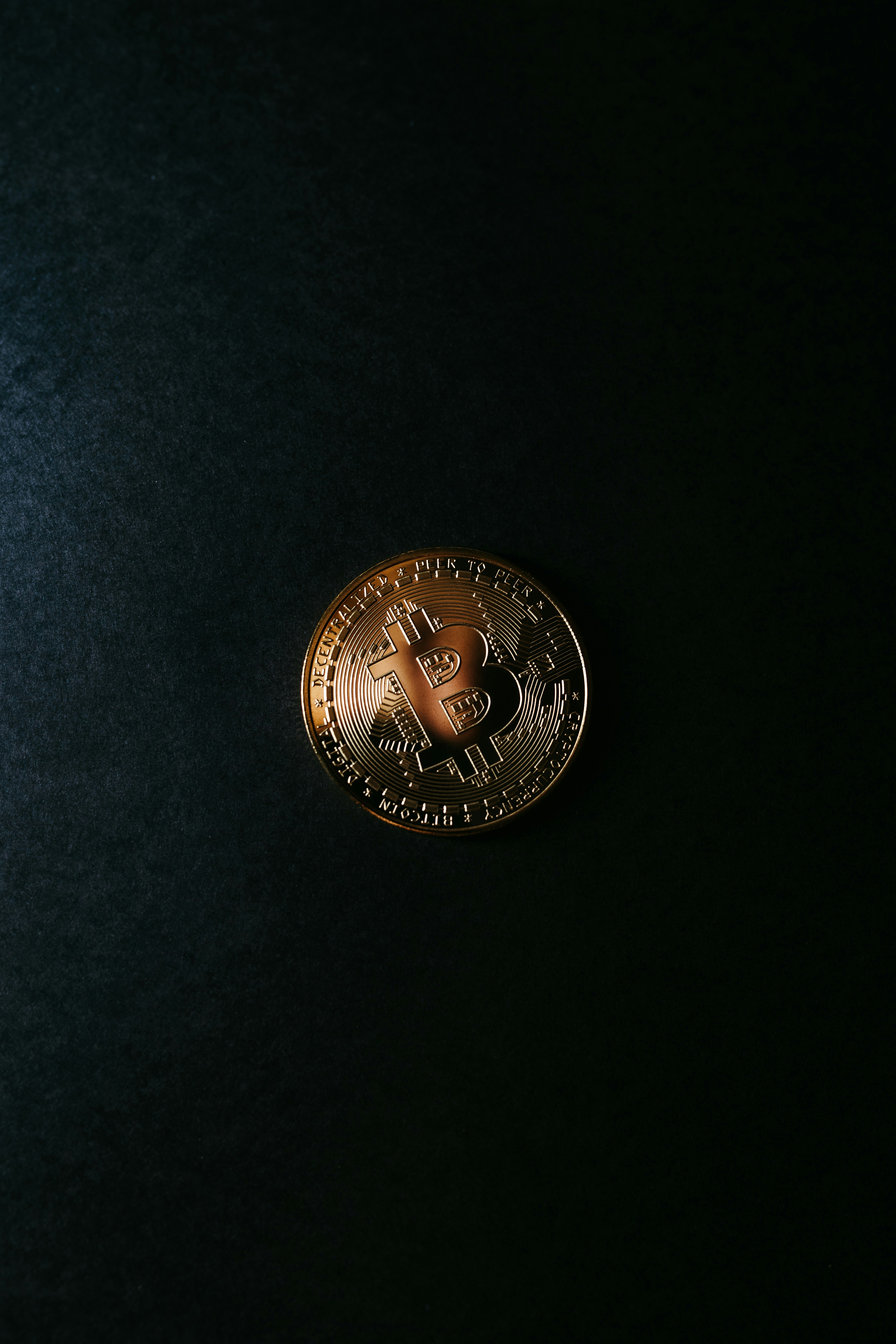 a bitcoin sitting on top of a black surface