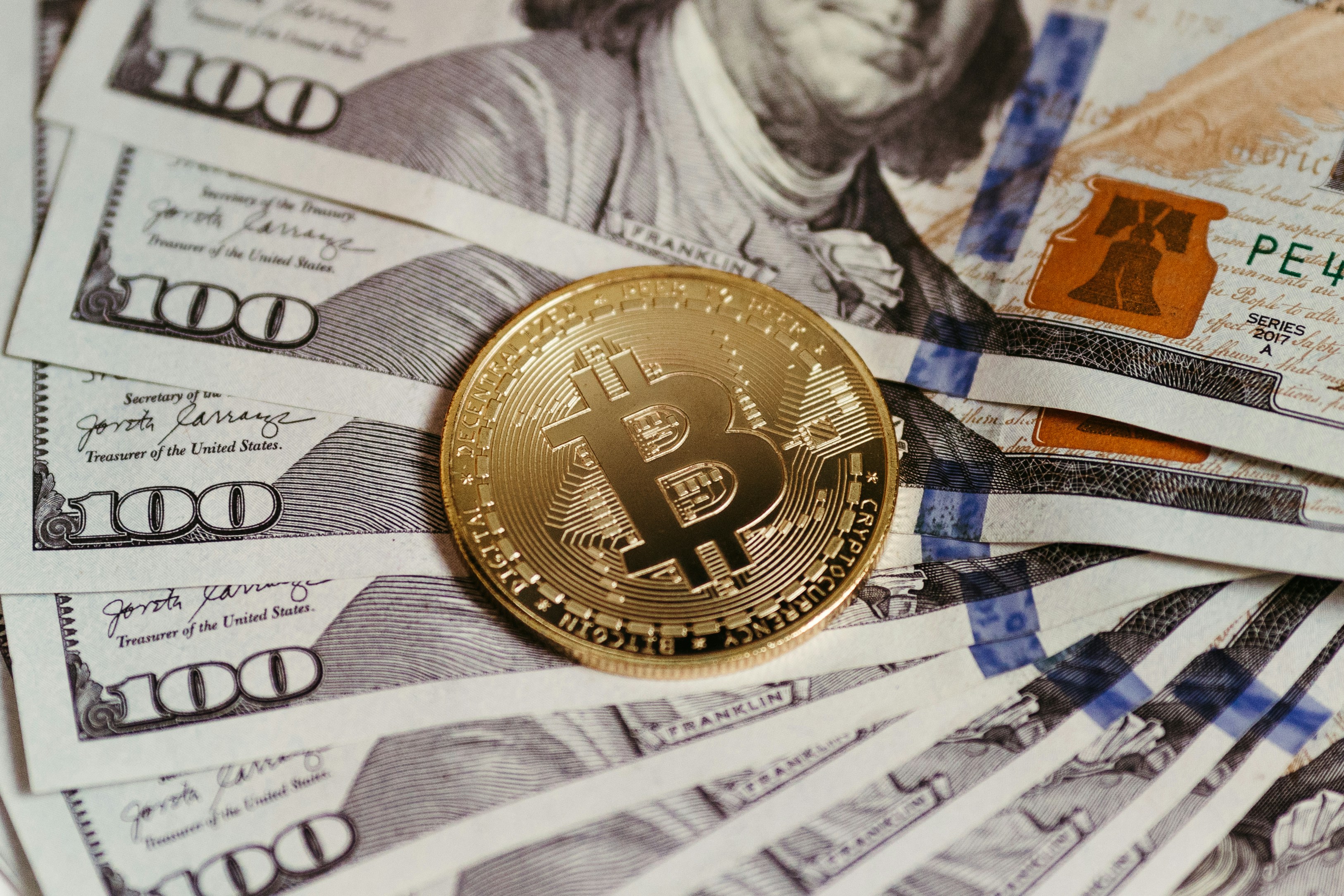 A $ 100 bill and a bitcoin on a table photo – Free Man Image on Unsplash