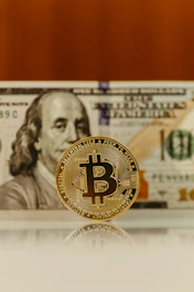 a bitcoin sitting on top of a stack of money