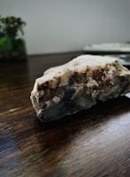 Close-up of raw minerals like copper and cobalt on a wooden table.