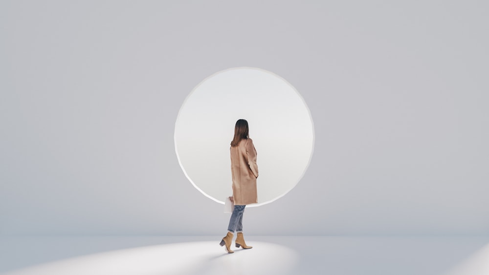 a woman standing in front of a round mirror