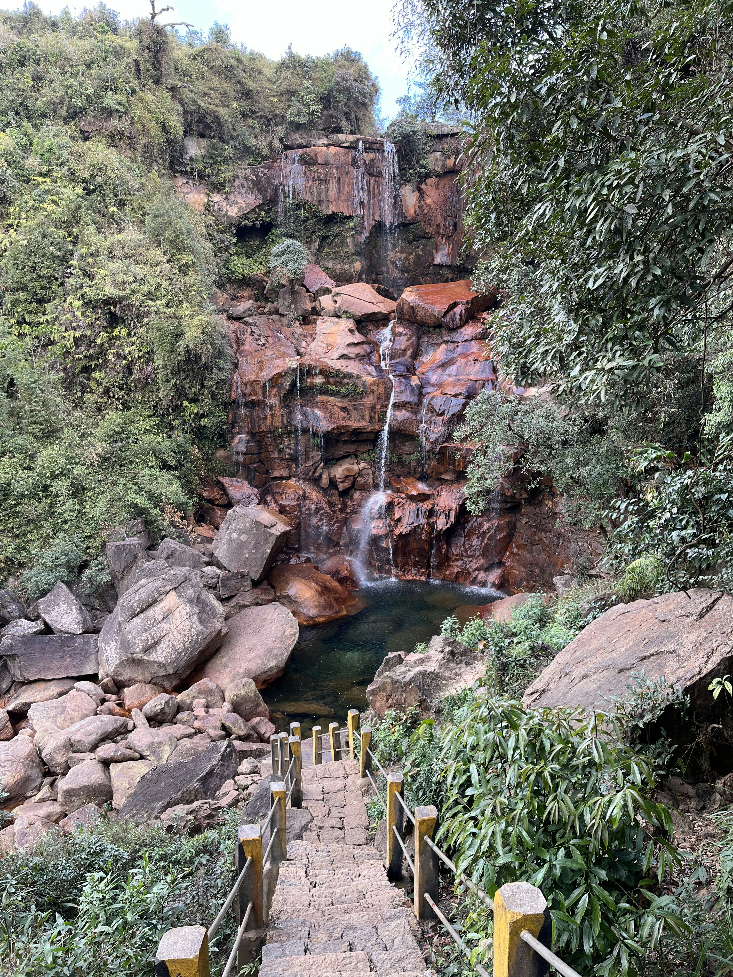stairs lead up to a waterfall with a waterfall in the background
