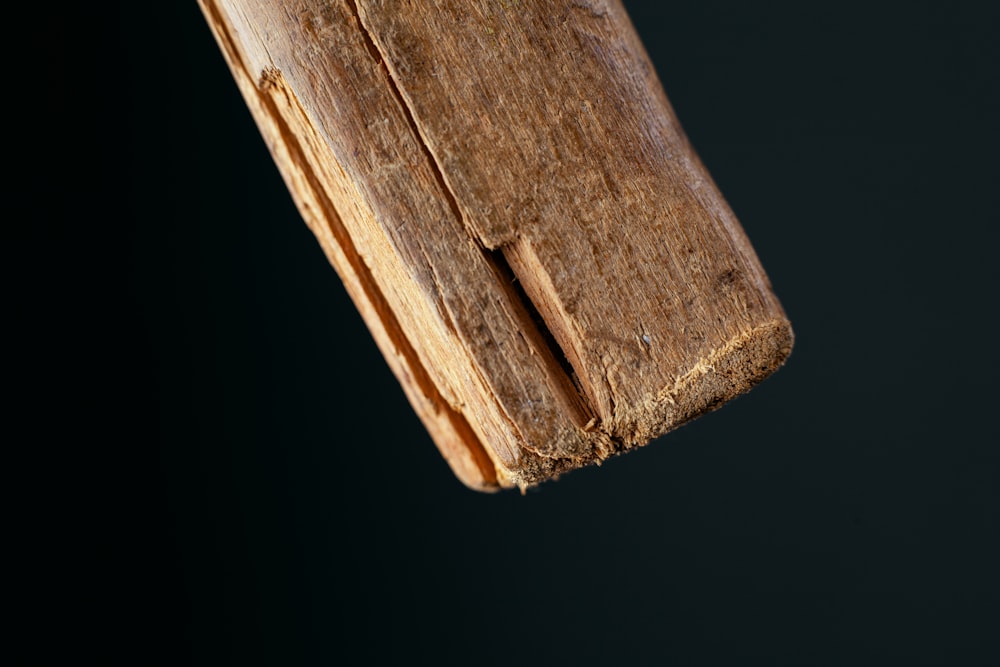 a close up of a piece of wood on a black background