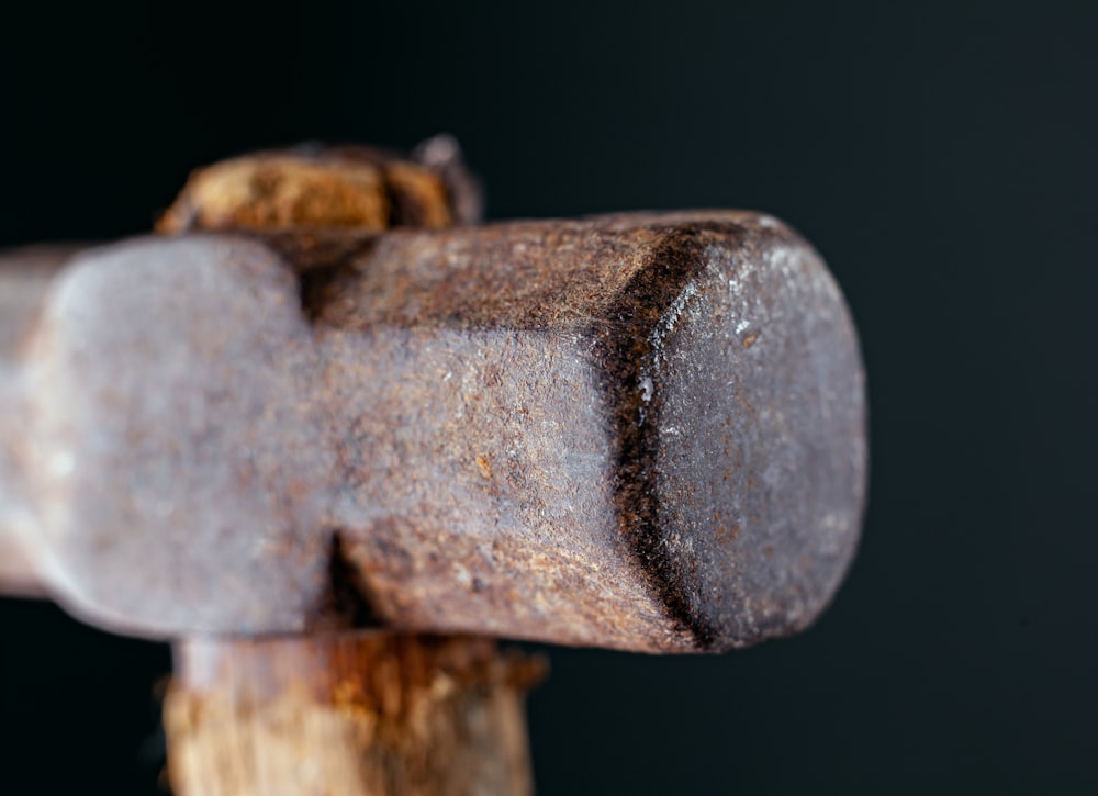 a close up of a hammer and a piece of wood