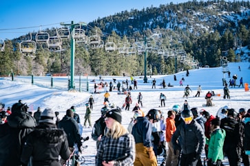 a crowd of people standing on top of a snow covered slope
