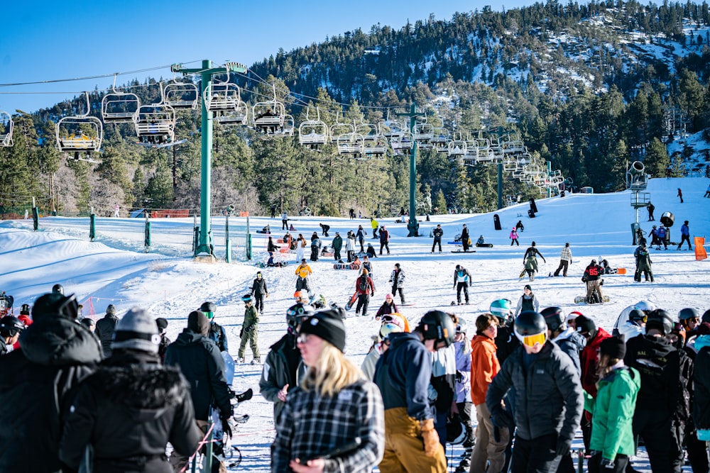 a crowd of people standing on top of a snow covered slope