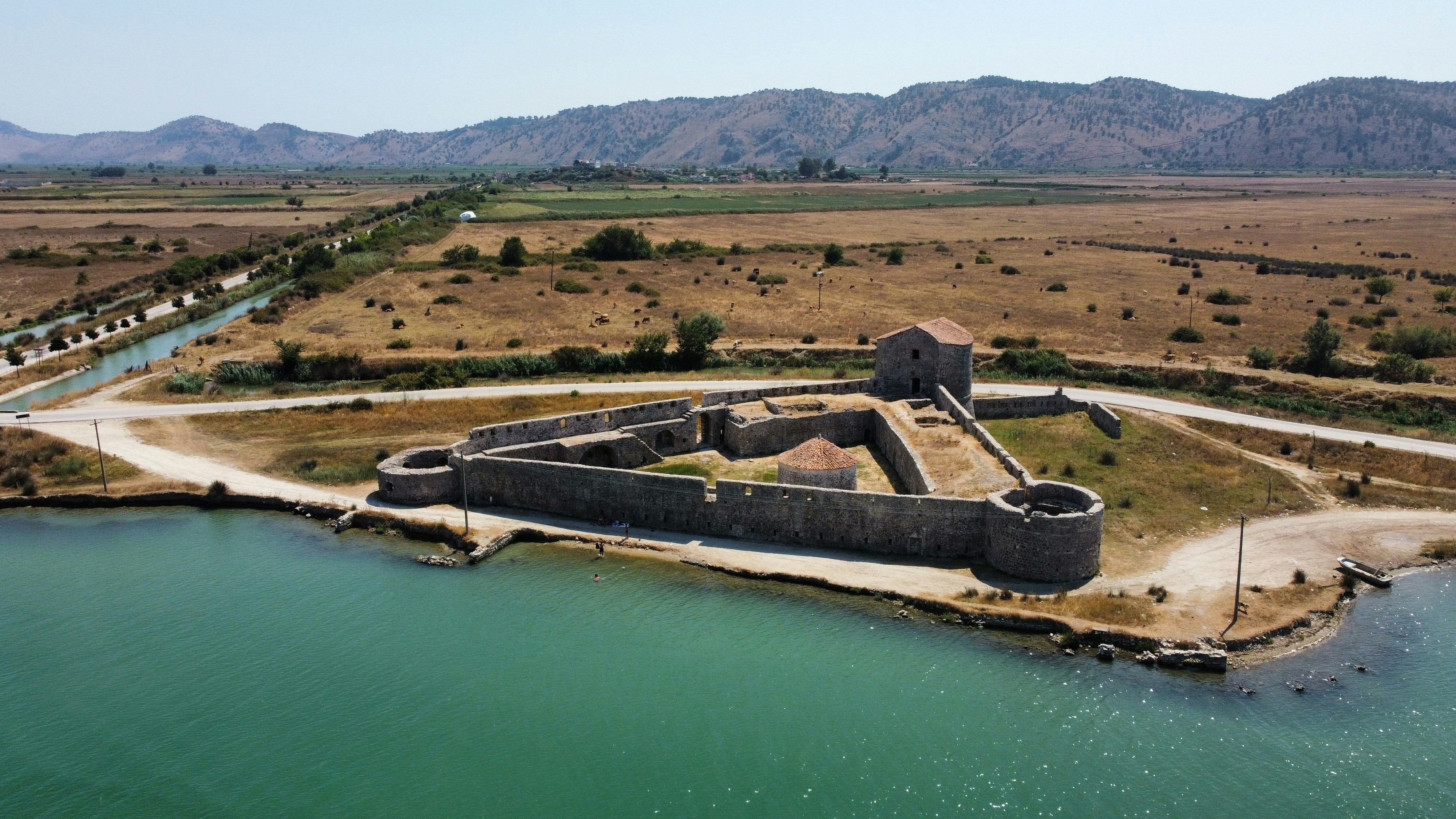 an aerial view of a large castle in the middle of a lake
