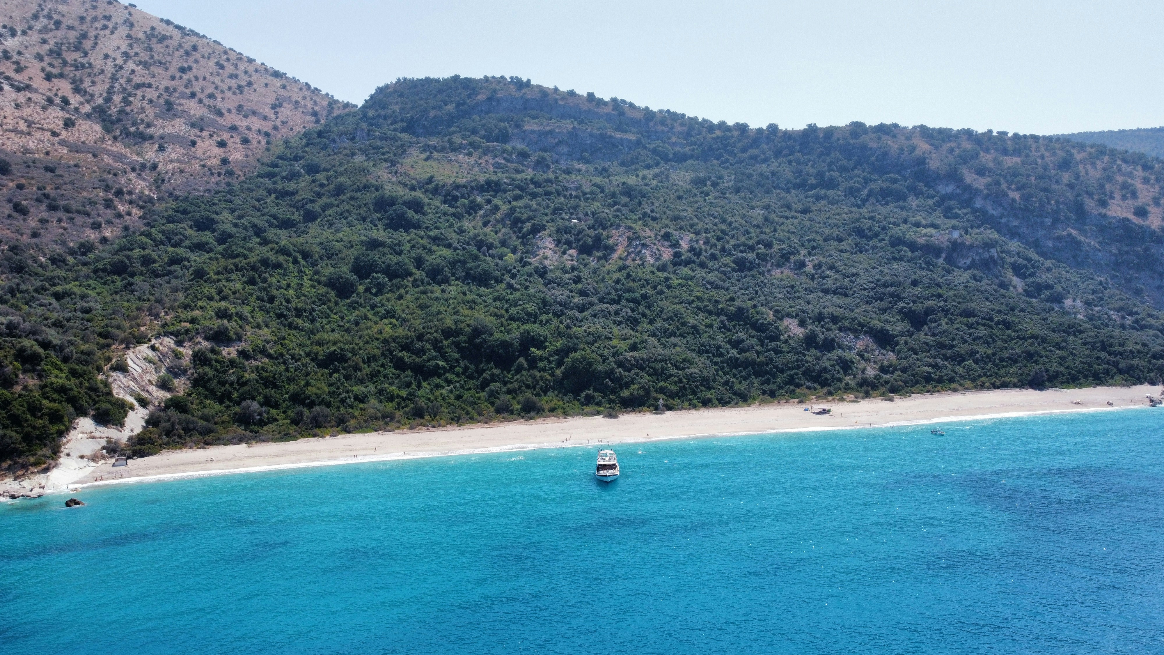 a boat is out on the water near a beach
