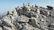 Group of climbers celebrating together near the peak of Mount Kinabalu under clear skies.