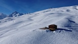 Snow-covered alpine landscape around the cabin in winter.