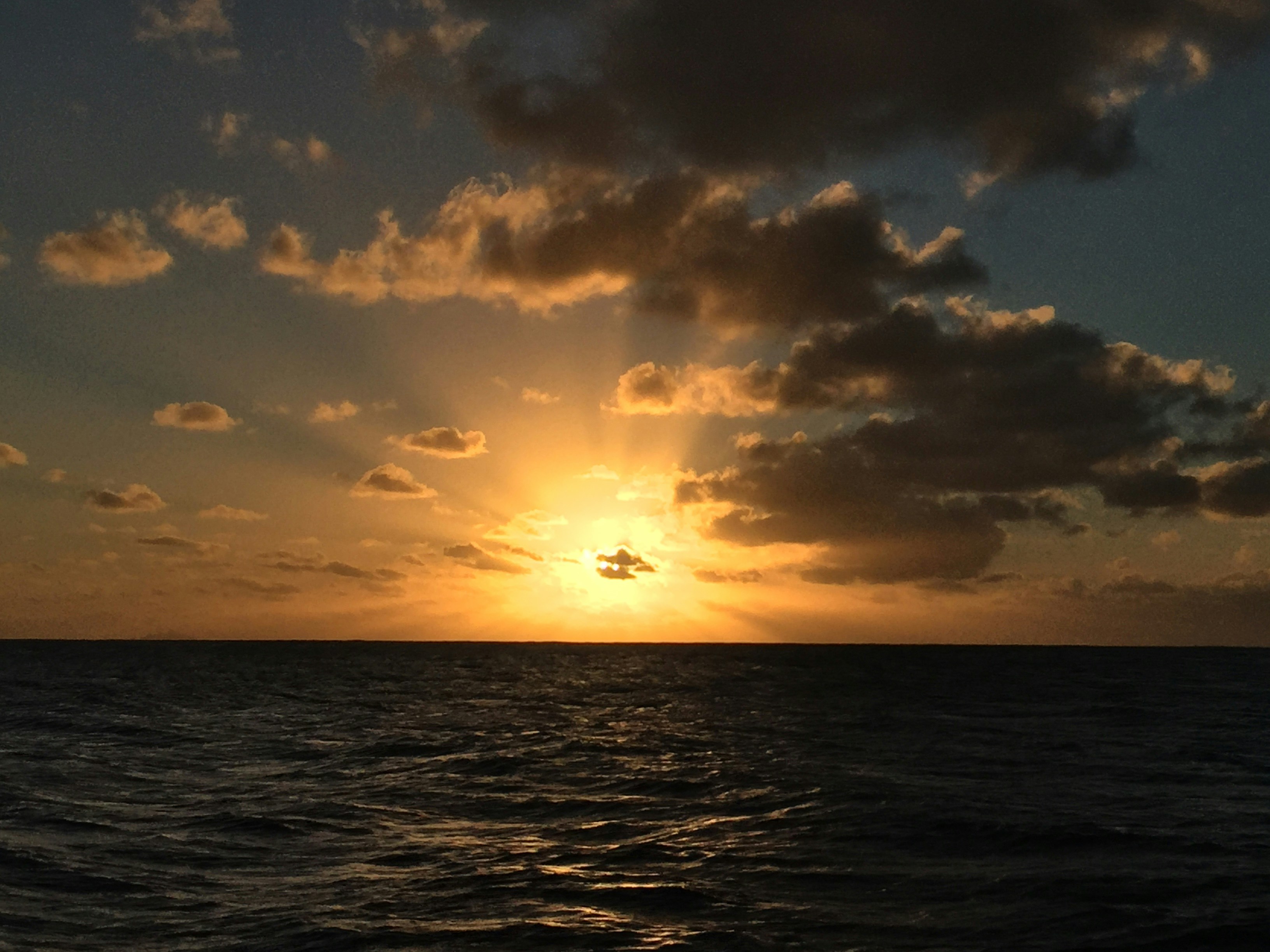 The sun is setting over the ocean on a cloudy day photo – Free French ...