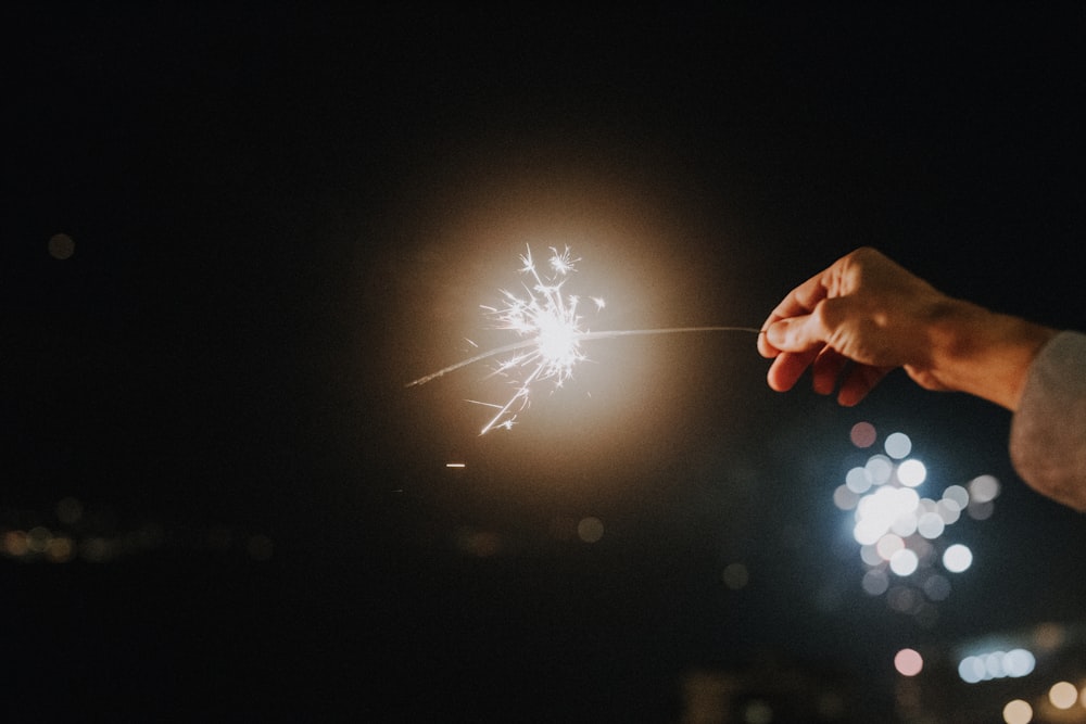 a person holding a sparkler in the dark