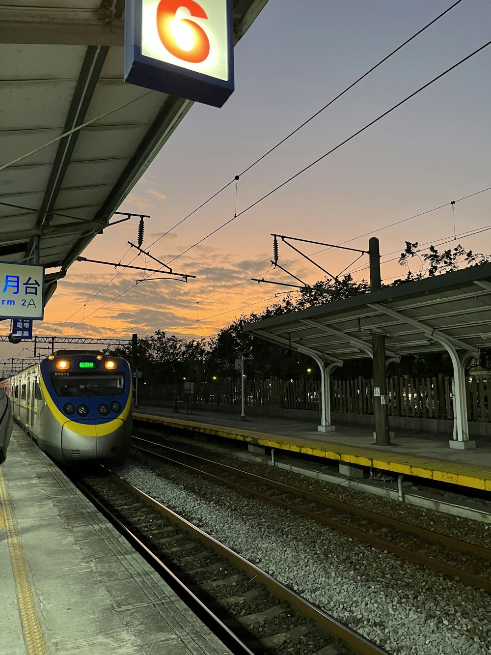 a train pulling into a train station at dusk