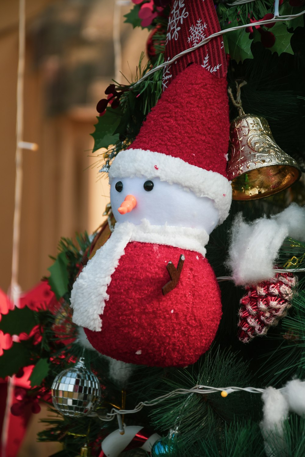 a snowman ornament hanging from a christmas tree