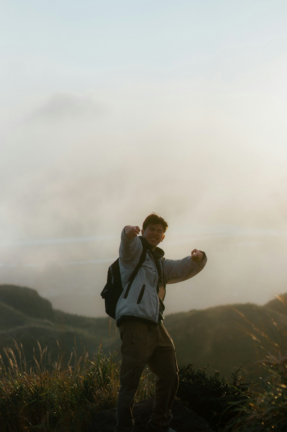 a man standing on top of a lush green hillside