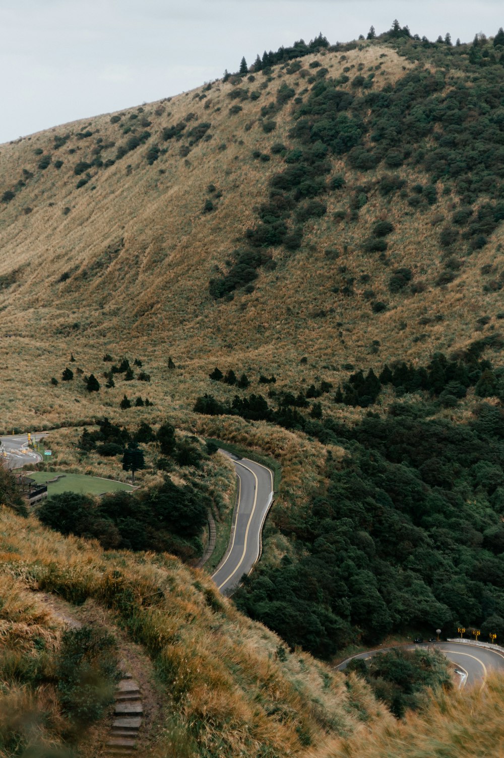 a winding road in the middle of a lush green hillside