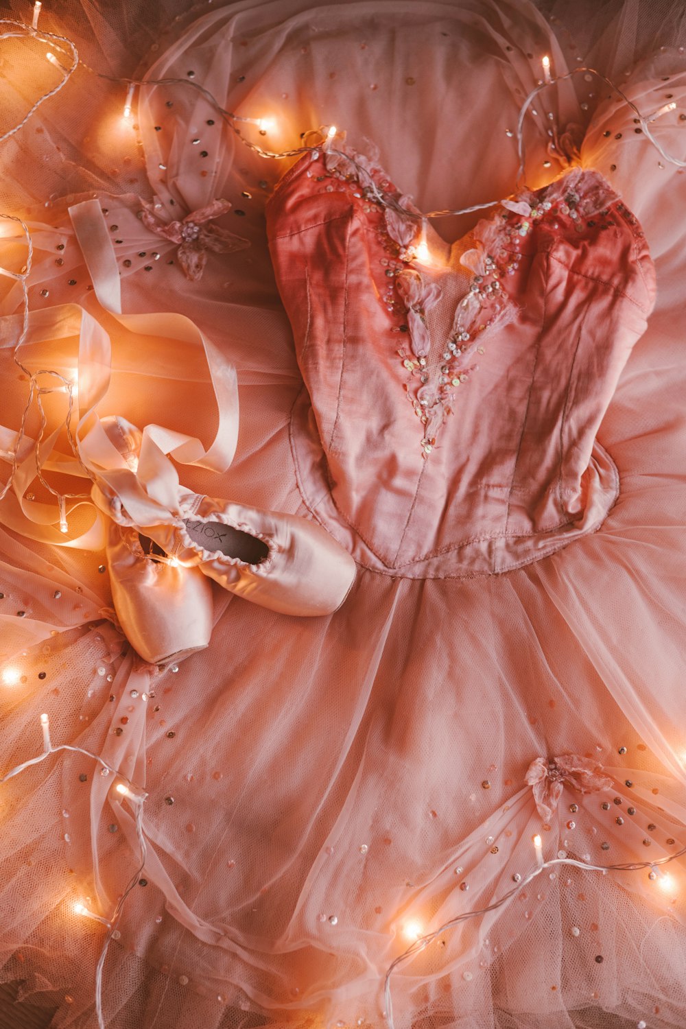 a ballerina's dress and ballet shoes are laying on the floor