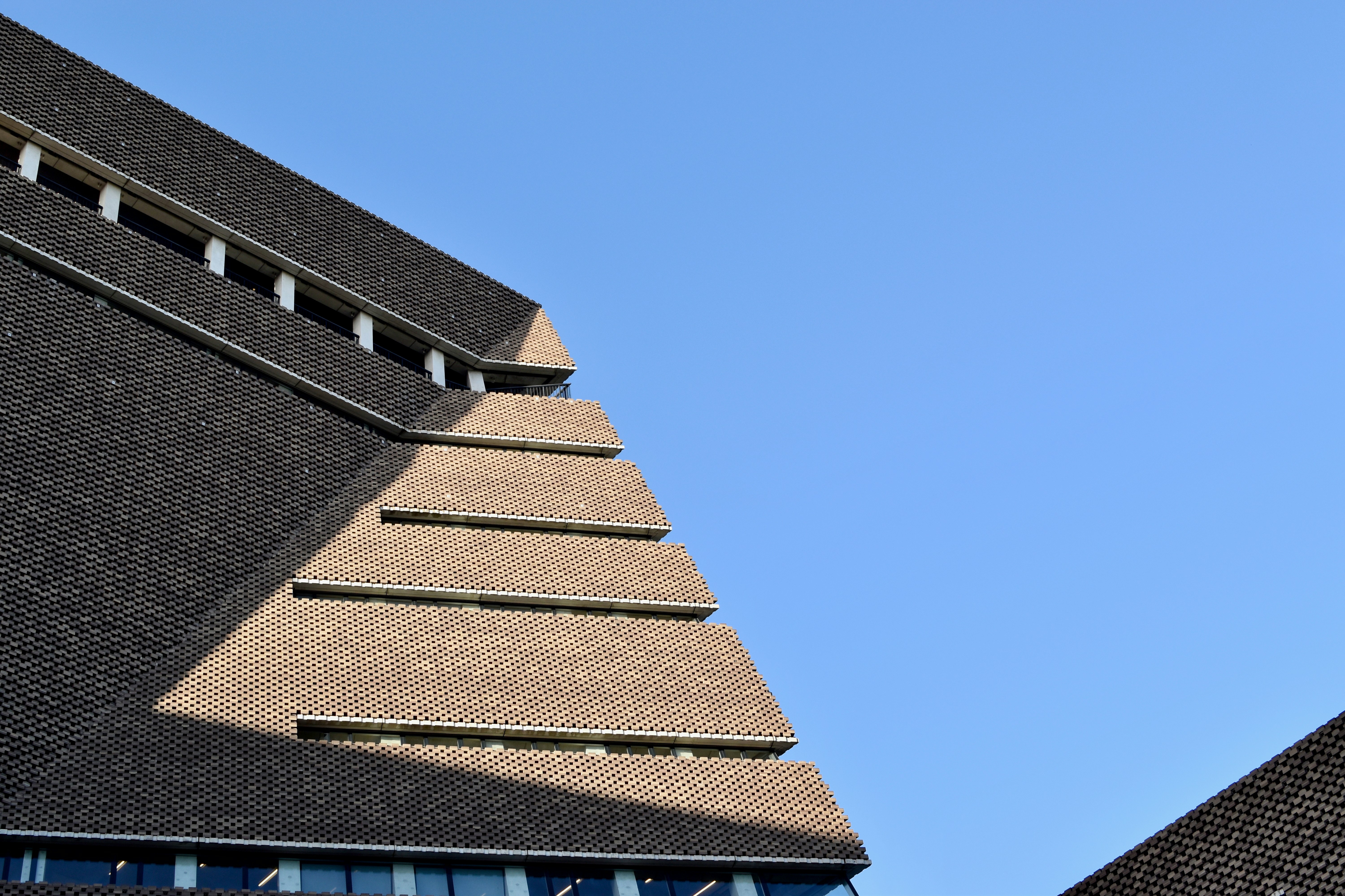 空の背景を持つ建物の側面にある時計