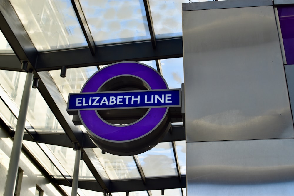 a blue and white sign hanging from the side of a building