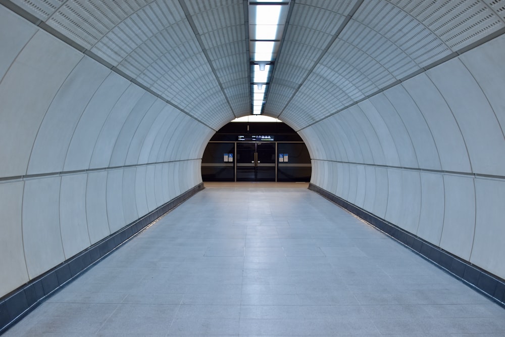 a long white tunnel with a bench in the middle of it