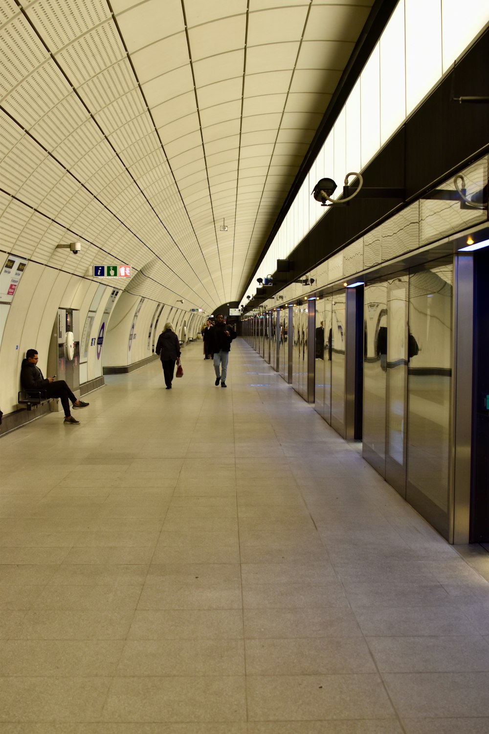 a subway station with people sitting on benches