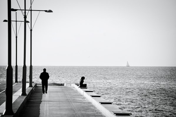 A man walking down a pier next to the ocean — İzmir, Turkey