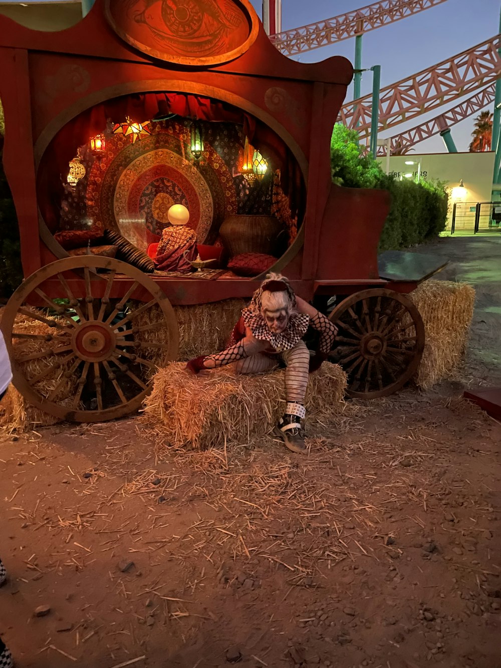 a little girl sitting on a hay cart