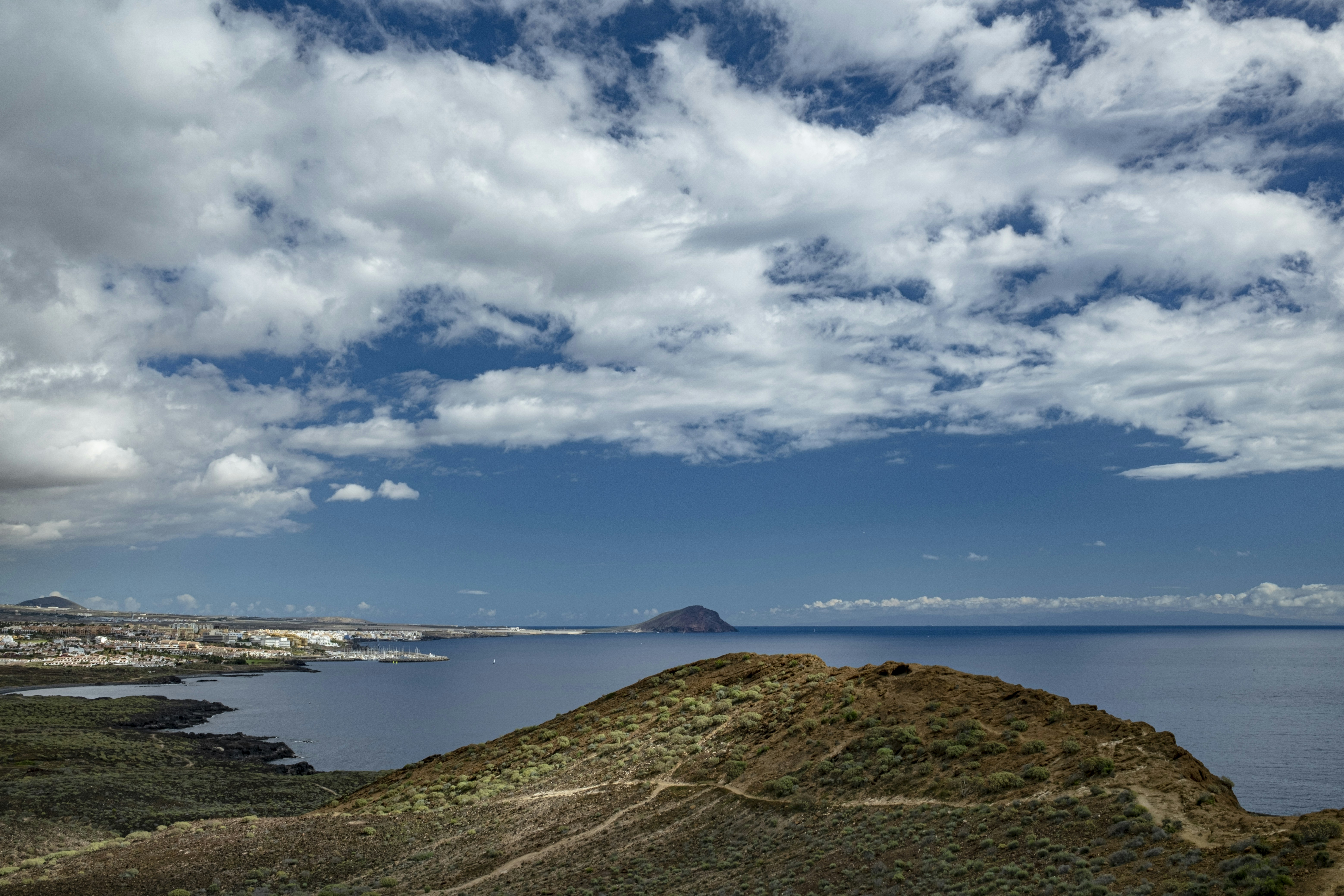 a large body of water sitting under a cloudy sky, 