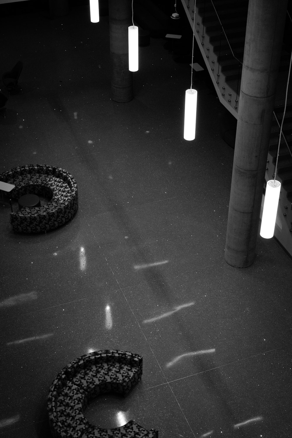 a black and white photo of a building with lights hanging from the ceiling