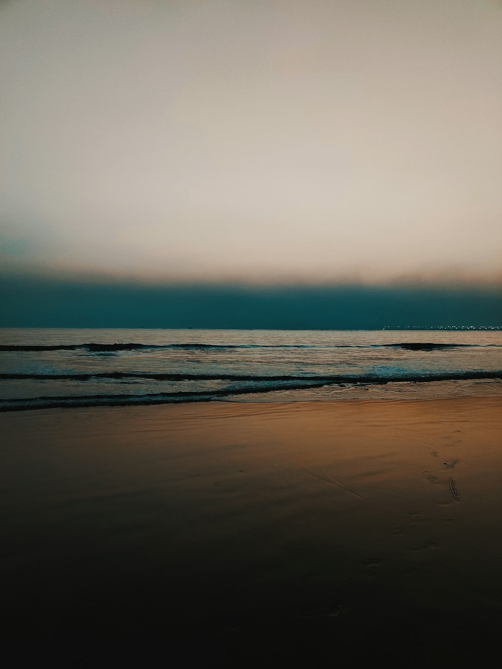 a person walking on a beach with a surfboard