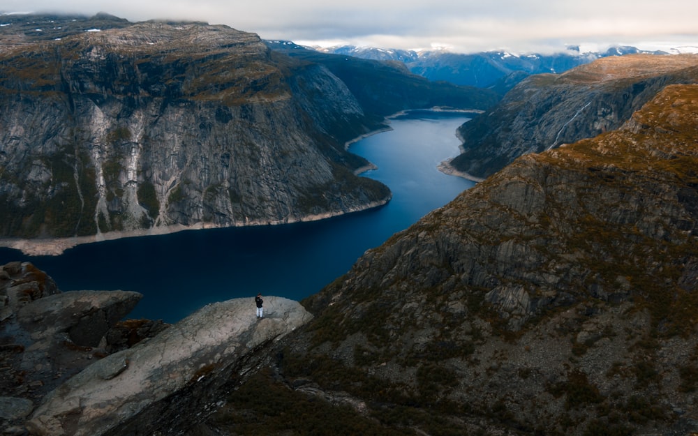 a person sitting on a rock overlooking a body of water