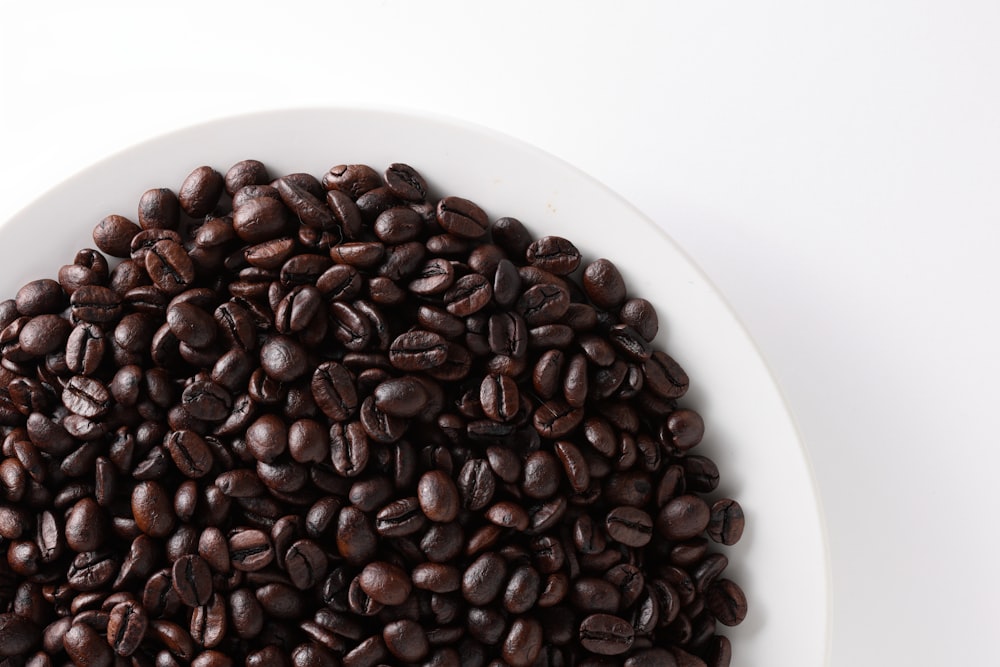 a white bowl filled with lots of coffee beans