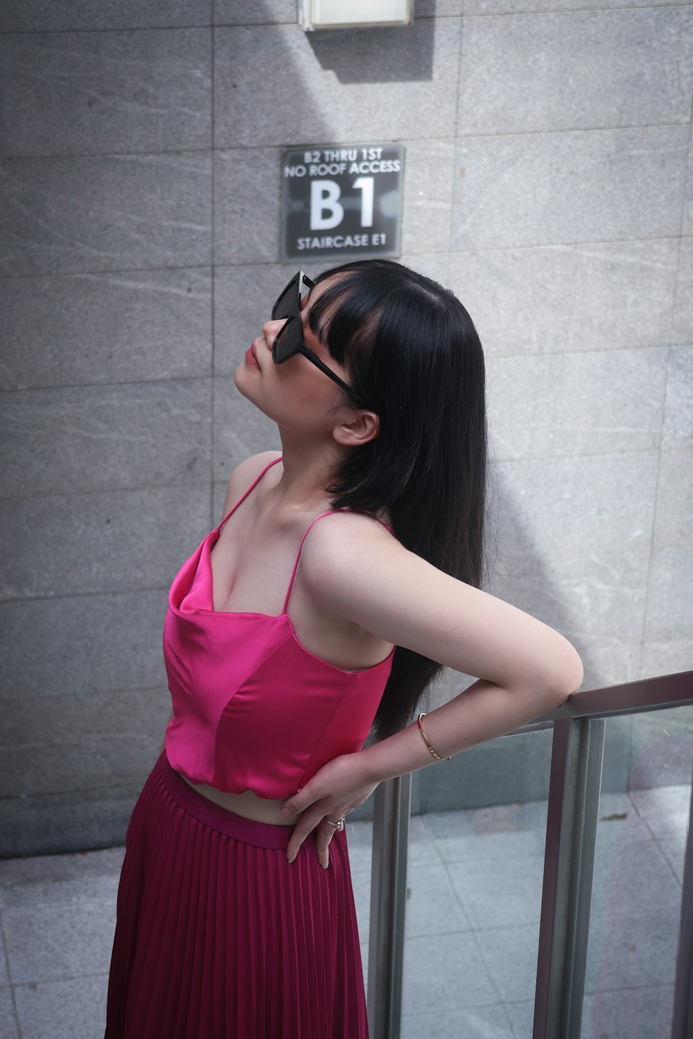 a woman in a pink top and a red skirt