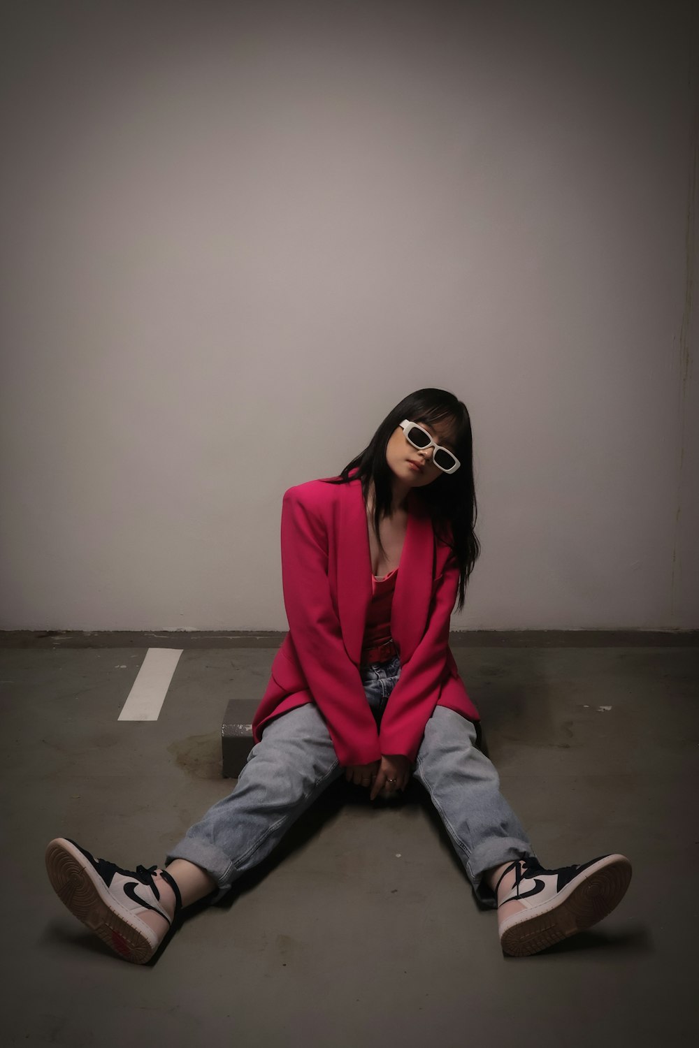 a woman sitting on the ground wearing sunglasses
