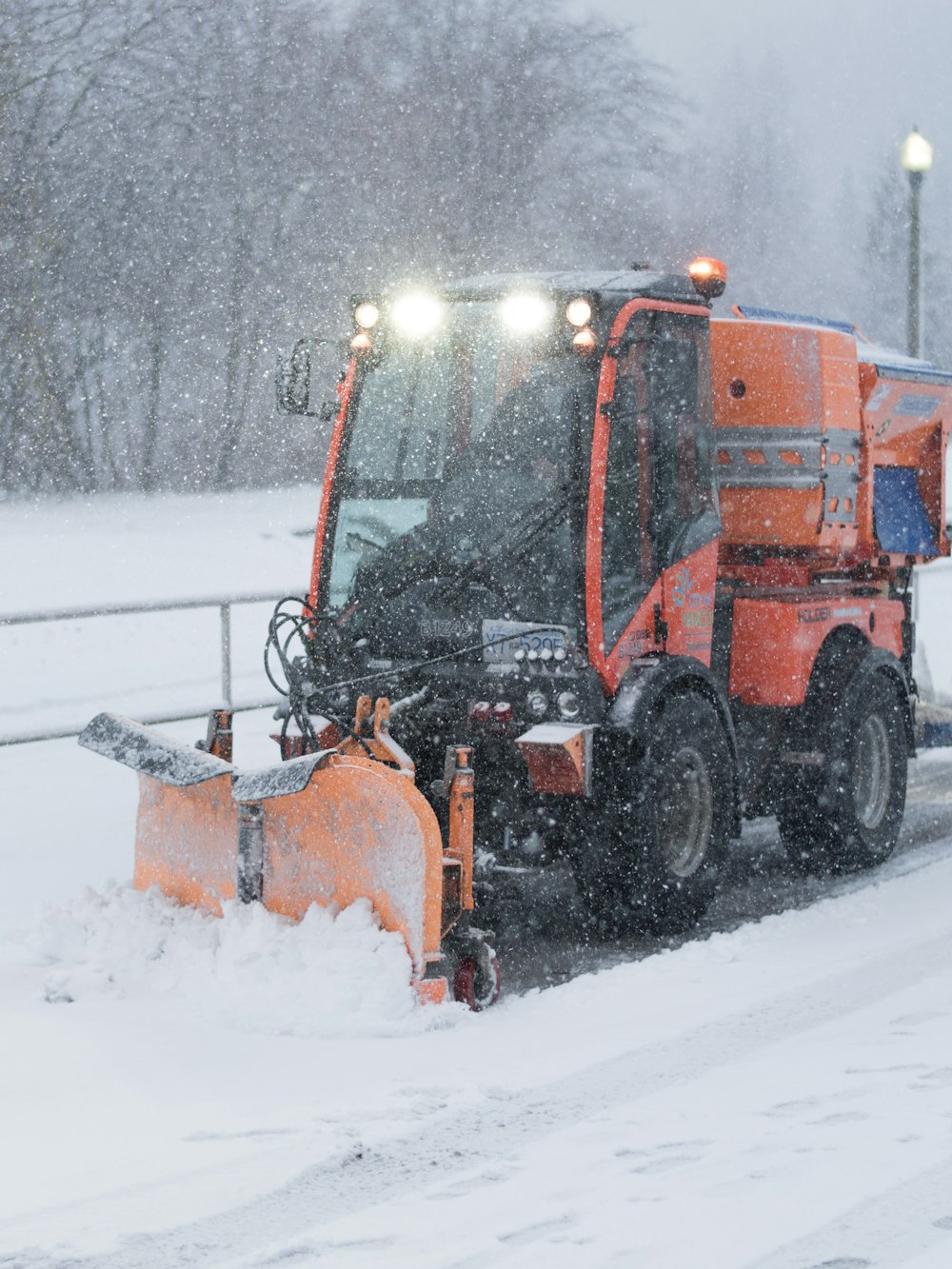 a snow plow driving down a snow covered road