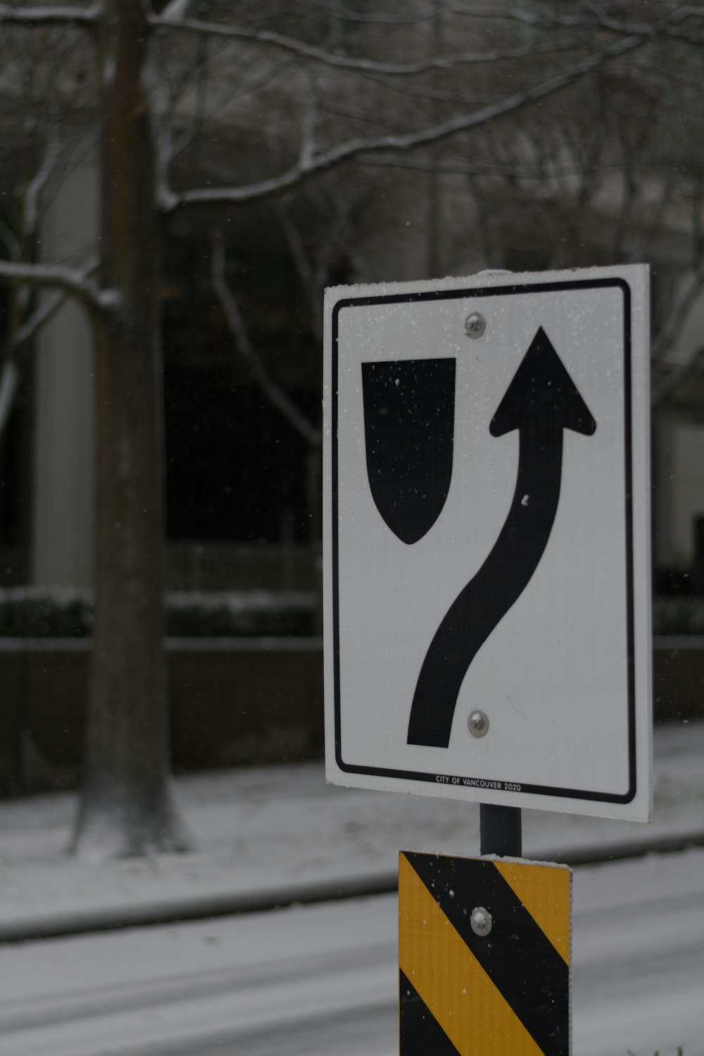 a street sign on a pole in the snow