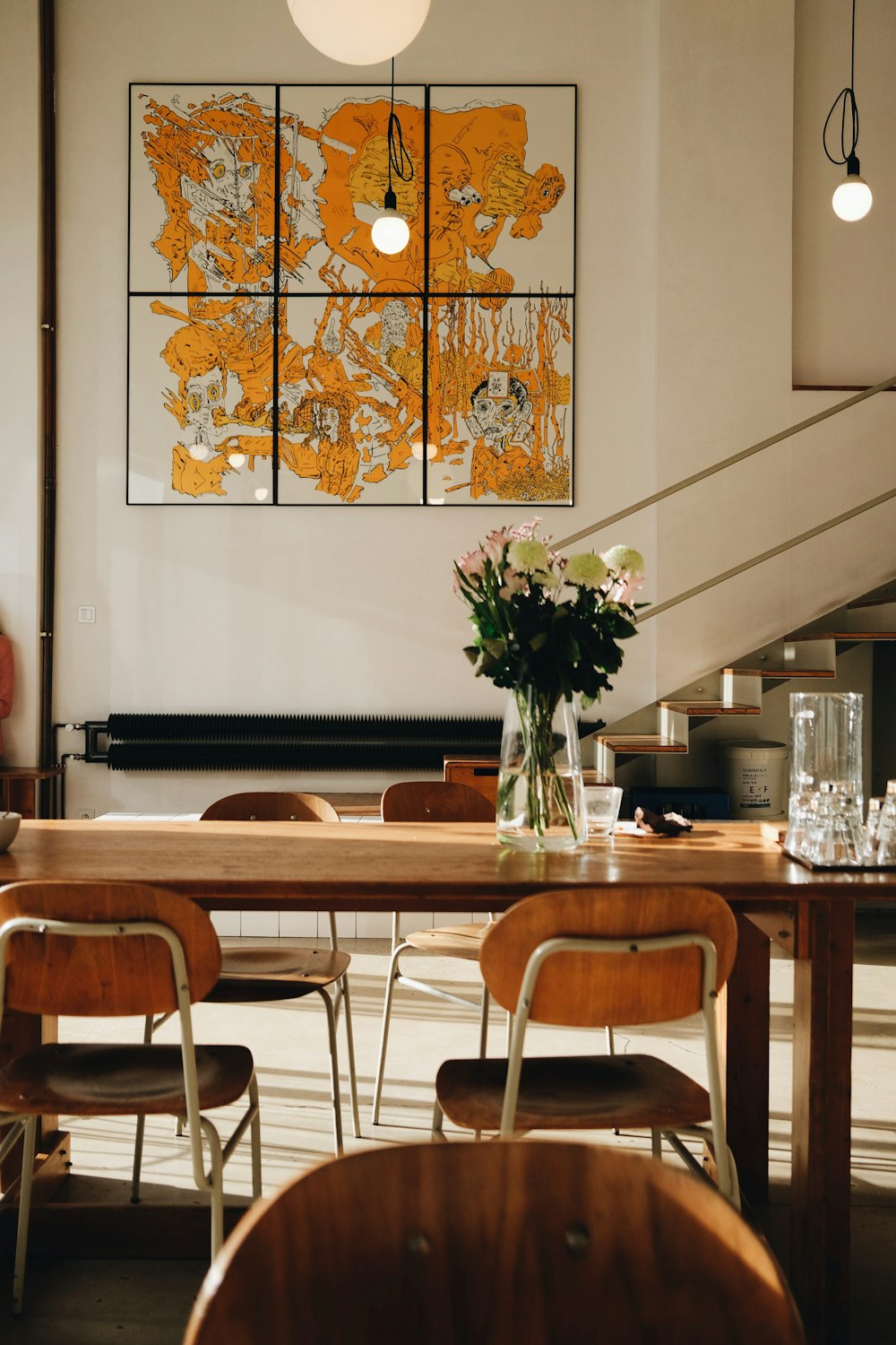 a dining room table with a vase of flowers on it