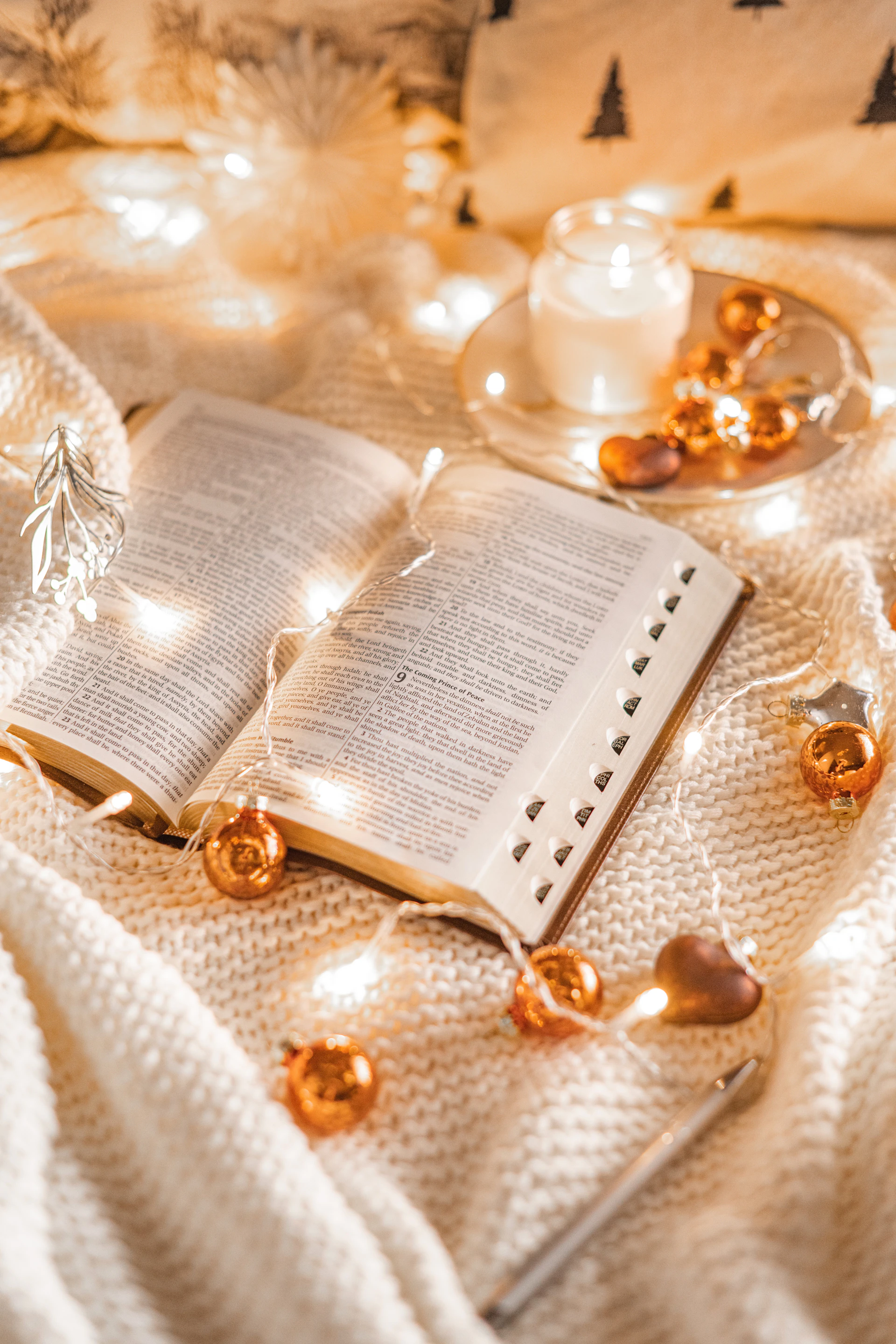 an open book sitting on top of a white blanket