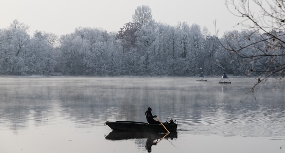 a person in a small boat on a lake