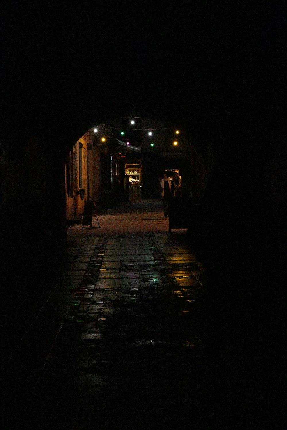 a dark tunnel with people walking in it