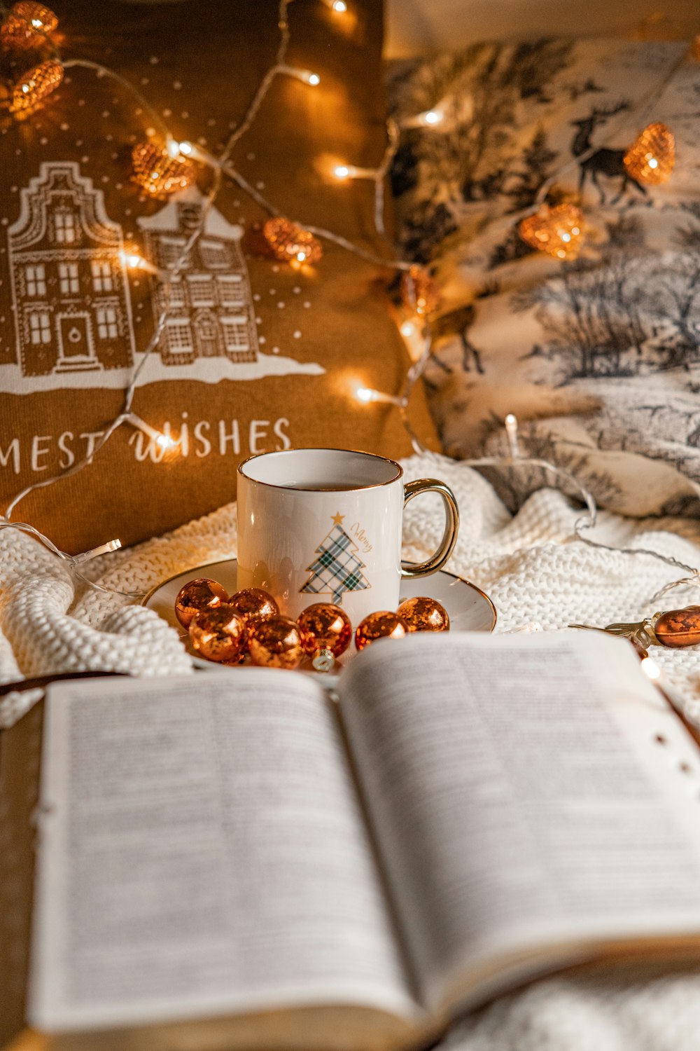 a cup of coffee and a book on a bed