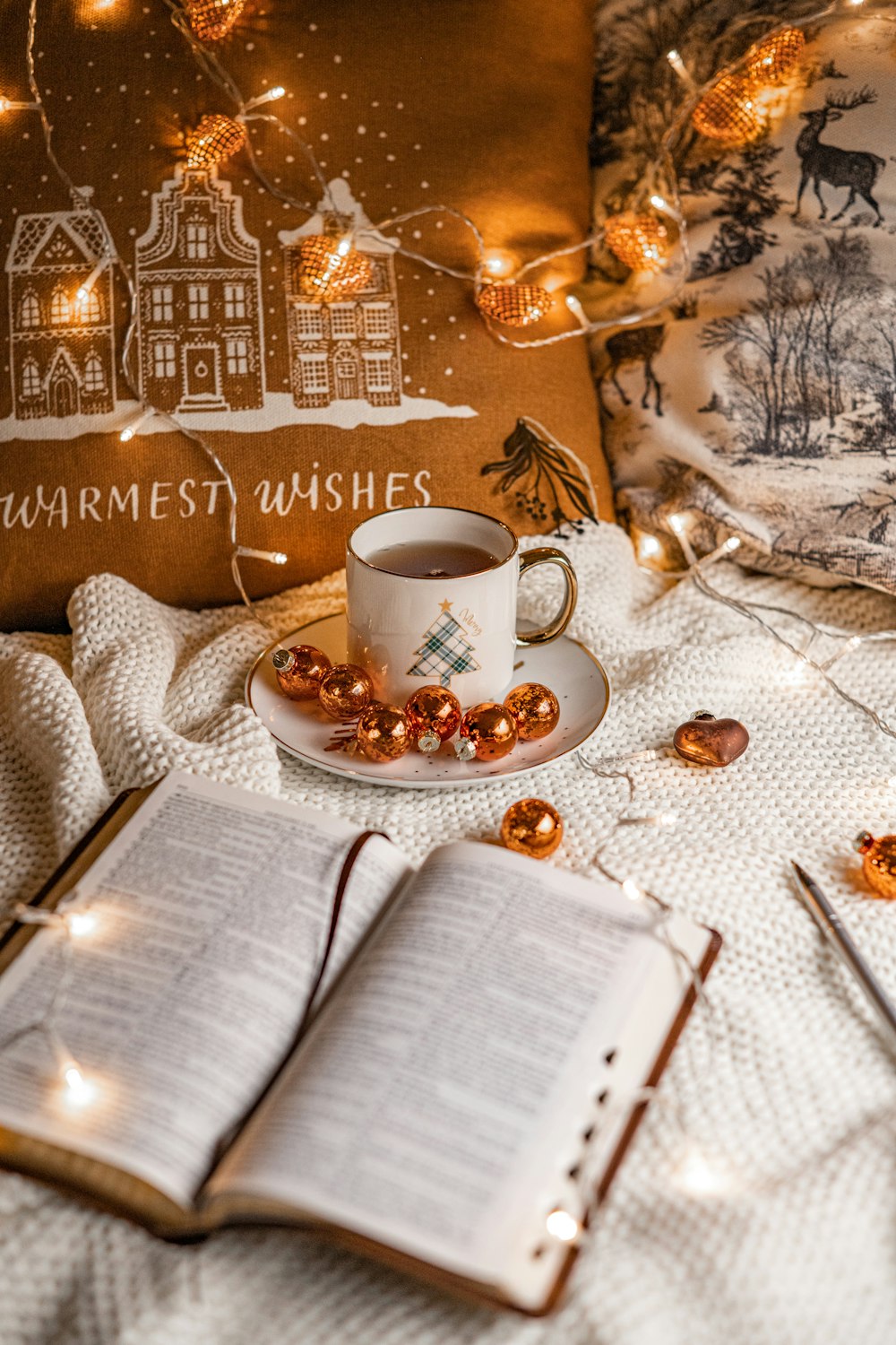 a cup of coffee and a book on a bed