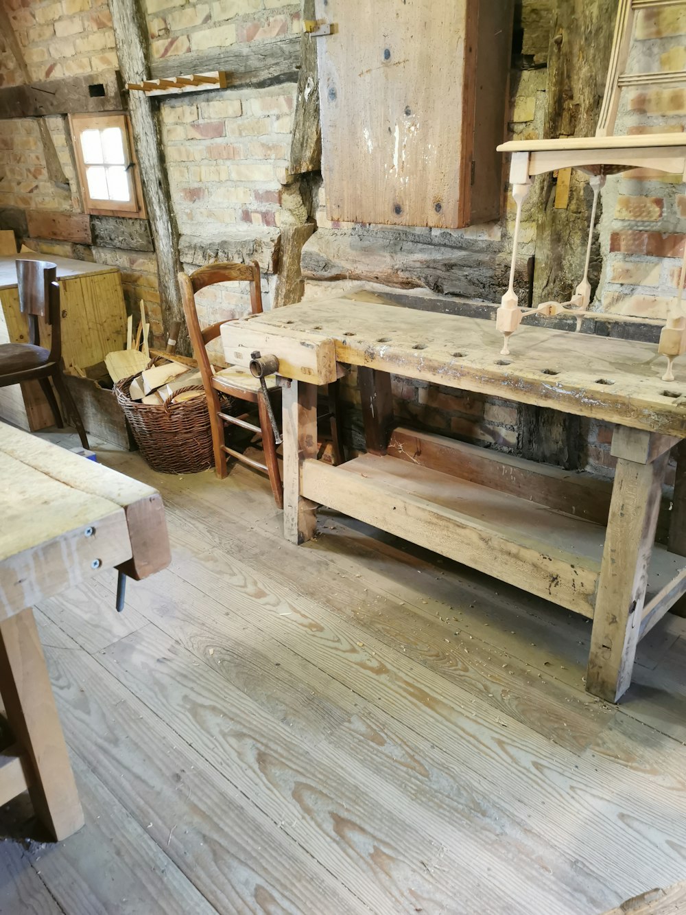 a wooden table sitting in a room next to a brick wall