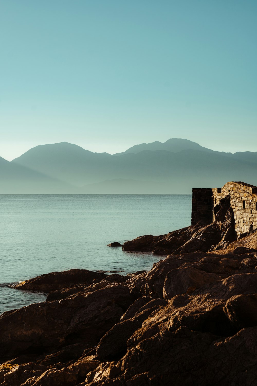 a large body of water sitting next to a rocky shore