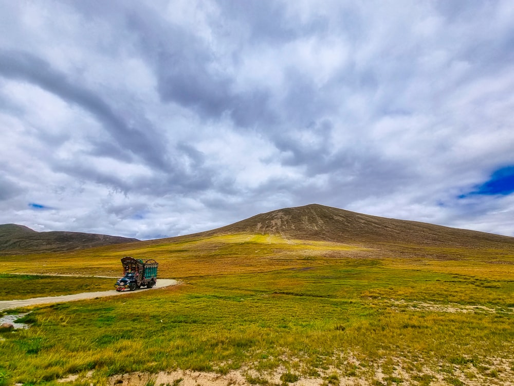 Un camion che percorre una strada sterrata attraverso un campo verde lussureggiante